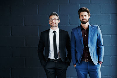 Portrait of businessmen against wall