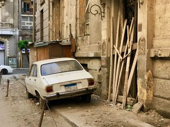 Abandoned car on street by building