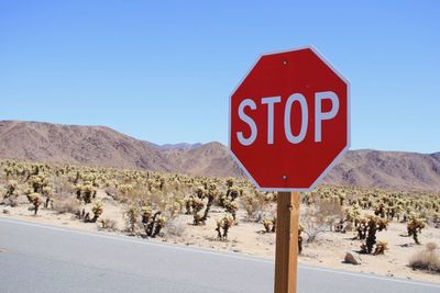 Road sign against clear blue sky