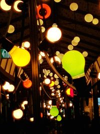 Low angle view of illuminated light bulbs hanging from ceiling