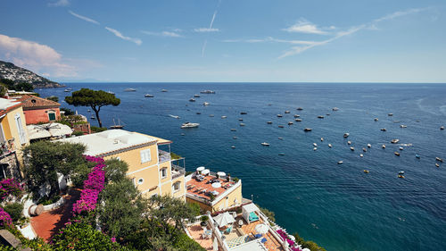 High angle view of townscape by sea against sky