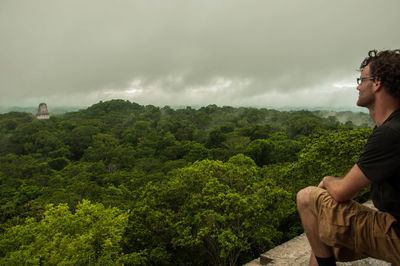 Man sitting looking over forest