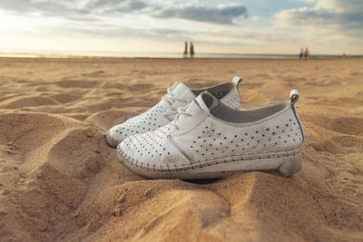 Close-up of shoes on sand