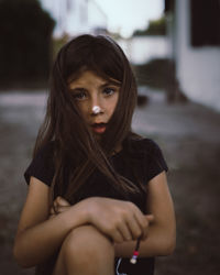 Portrait of a young woman sitting outdoors