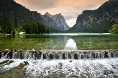 Scenic view of lake by mountains against sky