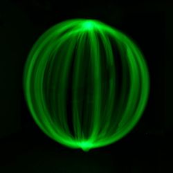 Green light painting against black background