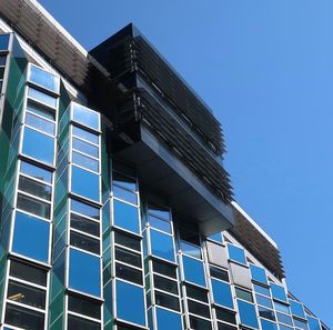 Low angle view of modern building against clear blue sky