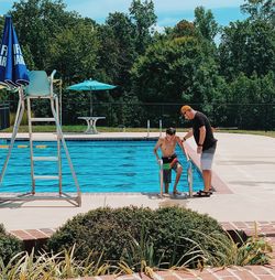 People in swimming pool against trees