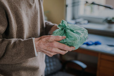 Midsection of woman holding flower at home