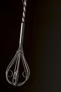 Close-up of wire whisk against black background