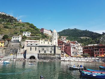 Buildings by river against sky in city