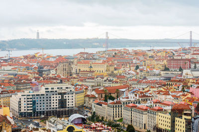 High angle view of townscape by sea against sky