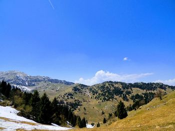 Scenic view of mountains against blue sky