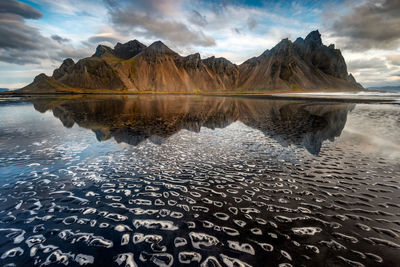 Scenic view of lake by mountains against sky