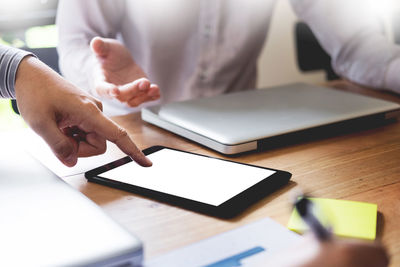 Close-up of woman using laptop on table