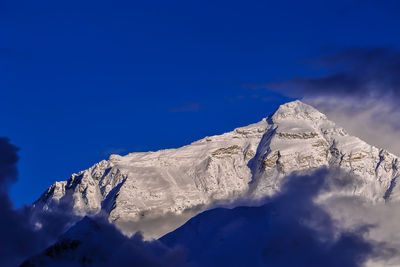 Scenic view of snowcapped mountains against blue sky