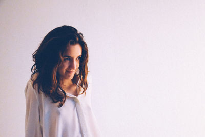 Portrait of young woman against white background