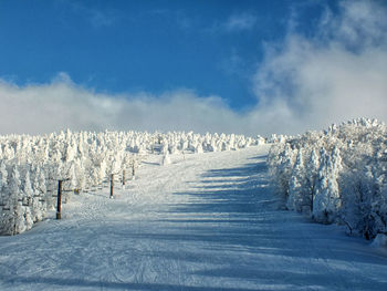 Snow covered landscape against blue sky