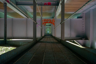 Empty walkway in illuminated tunnel