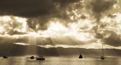 Sailboats in sea against sky