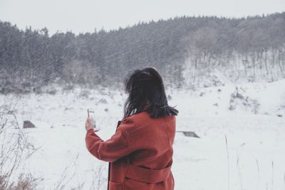 Rear view of woman standing in snow