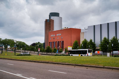 Road by factory against sky in city