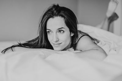 Portrait of young woman lying on bed