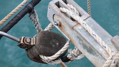 Close-up of rope tied to wooden post in sea