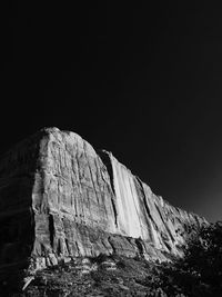 Low angle view of rocky landscape against clear sky