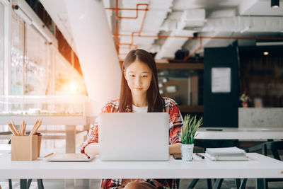 Woman working with laptop in restaurant