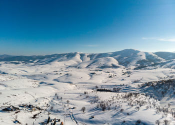 Scenic view of snowcapped mountains against clear blue sky