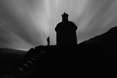 Silhouette of man standing on lighthouse