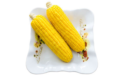 High angle view of vegetables in plate against white background