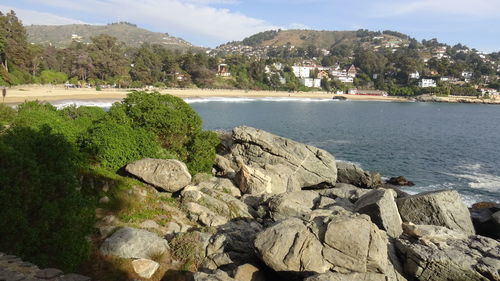 Rocks by sea against sky