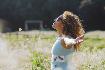 Side view of young woman standing on field