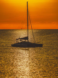 Silhouette sailboat on sea against sky during sunset