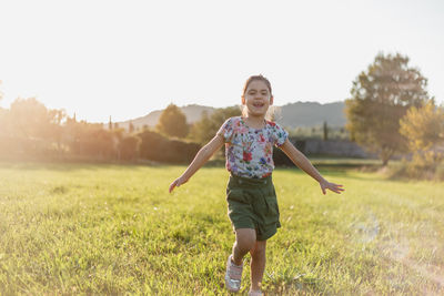 Portrait of young woman standing on grassy field
