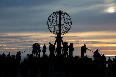 Silhouette people against sky during sunset