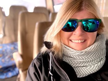 Portrait of a smiling young woman winter scarf and sunglasses