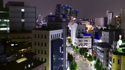 High angle view of illuminated buildings against sky at night