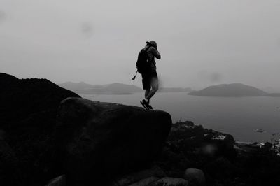 Full length of man walking on rock against sky