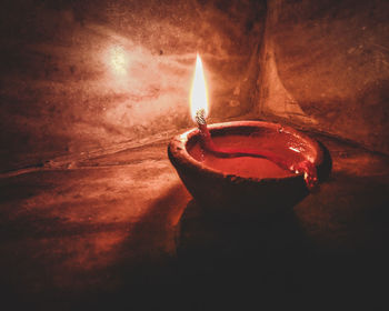 Close-up of lit candle in the dark