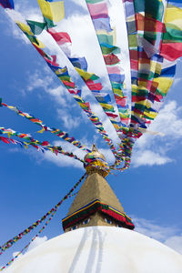 Low angle view of flags hanging against sky