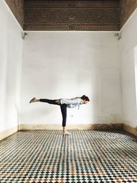 Rear view of woman standing against wall