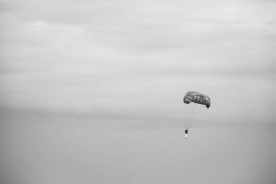 Low angle view of person paragliding against sky