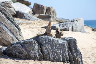 Stack of rocks on beach against clear sky