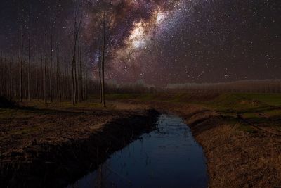 Scenic view of lake against sky at night