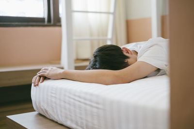 Woman lying on bed at home