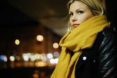 Portrait of woman in illuminated park during winter at night