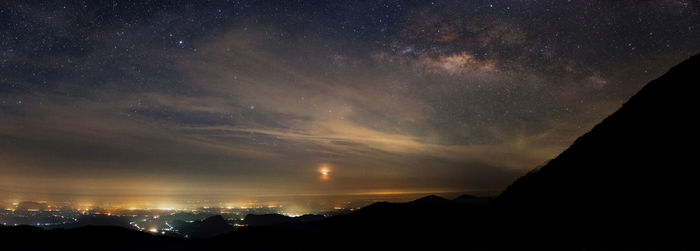 Scenic view of silhouette mountains against sky at night